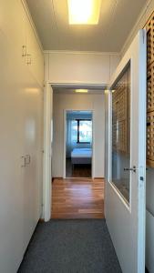 a hallway with a door leading to a room with a bed at Huoneisto karhujen kaupungissa - Tapanintien Lumo in Ähtäri
