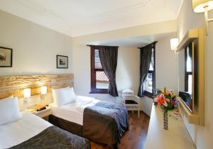 Cette chambre comprend deux lits et une télévision. dans l'établissement Aspen Hotel Kaleiçi, à Antalya