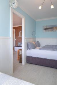 ein Schlafzimmer mit einem Bett und einer Uhr an der Wand in der Unterkunft Duen12_45 in Westerland