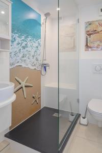 ein Bad mit einer Glasdusche und einem WC in der Unterkunft Duen12_45 in Westerland