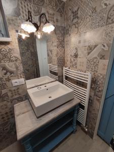 ein Badezimmer mit einem weißen Waschbecken und einem Spiegel in der Unterkunft Apartman Šumiac 4 in Šumiac