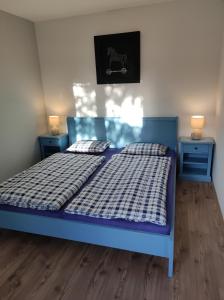 a blue bed in a room with two blue tables at Apartman Šumiac 4 in Šumiac