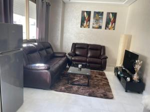 uma sala de estar com um sofá de couro e uma mesa em Appartement Casablanca Maarif em Casablanca