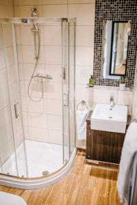 een badkamer met een douche en een wastafel bij The Bull Hotel in Stony Stratford