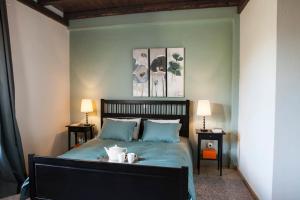 a bedroom with a bed with blue sheets and two lamps at Bezeniko Amazing Arcadian Property! in Vlakhérna