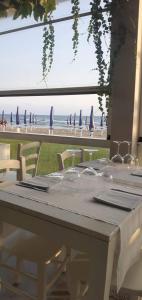a table with chairs and a view of the beach at Appartamento Marina D’Ardea vista mare in Ardea +4 photos
