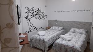 a bedroom with two beds and a tree mural on the wall at Aer Sana in Arzana