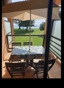 een tafel en stoelen met een parasol op een veranda bij Chez Céline & Rudi in San-Nicolao