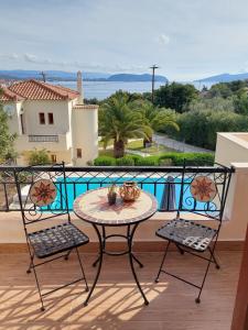 a table and two chairs on a balcony with a view at Villa Nova s.r Sea View in Porto Heli