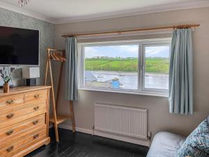 a bedroom with a window with a view of a river at Ferry View in Cardigan