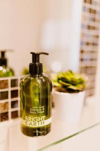 a green soap bottle sitting on top of a counter at The Bull Hotel in Stony Stratford