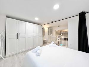 拉科魯尼亞的住宿－Apollo Project Coruña，白色卧室配有白色橱柜和大床