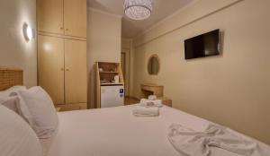 sypialnia z białym łóżkiem z ręcznikiem w obiekcie Hotel Viky w mieście Sarti