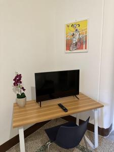 una TV su un tavolo di legno in una stanza di Le stanze di Regina Margherita a Palermo