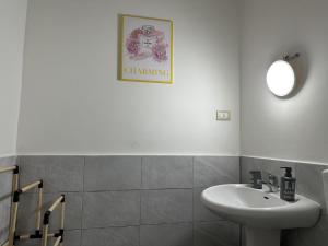 a white bathroom with a sink and a mirror at Le stanze di Regina Margherita in Palermo