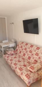 sypialnia z łóżkiem i telewizorem na ścianie w obiekcie appartement au pied des pistes w mieście Orcières