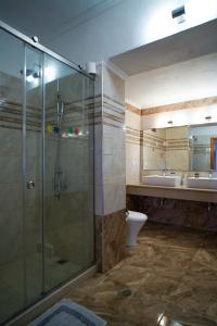 y baño con ducha, aseo y lavamanos. en Kostas Beach Apartments en Agios Gordios