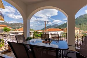 einen Balkon mit einem Tisch, Stühlen und Bergen in der Unterkunft Katerina & Elia's Family House in Leonidi