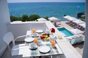 a table with a bowl of fruit and a bowl of fruit at Kostas Beach Apartments in Agios Gordios