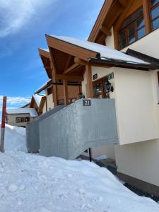 een gebouw met een hek in de sneeuw bij FAMILIENAPPARTMENT MIT GARTEN - Gerlitzen in Deutschberg