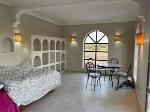 a bedroom with a bed and a table and chairs at Palast - Ruheoase Essaouira in Ouled Khellouf