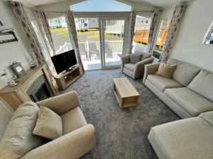 a living room with two couches and a television at 3 Bedroom Caravan LG34, Lower Hyde, Shanklin in Shanklin