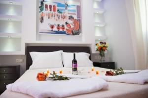 a bed with candles and a bottle of wine on it at Anemi Leros Apartments in Panteli