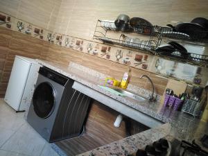 eine Küche mit einer Waschmaschine und einem Waschbecken in der Unterkunft Your House For Family in Agadir