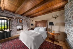 - une chambre avec un lit et un mur en pierre dans l'établissement Sakali Mansion, à Pinakátai