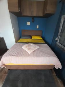 Ce lit se trouve dans un dortoir doté d'un mur bleu. dans l'établissement Studio apartman T and T, à Ražanac