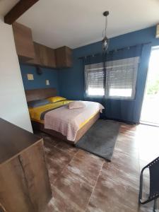 - une chambre avec un lit et un mur bleu dans l'établissement Studio apartman T and T, à Ražanac