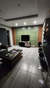 a living room with a couch and a flat screen tv at Lloyds - 3 in Ermelo