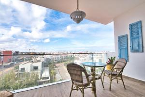 ein Esszimmer mit einem Tisch und Stühlen sowie einem großen Fenster in der Unterkunft Luxury Apartment 90sqm with Pool near Beach WIFI Unlimited Optical Fiber in Agadir