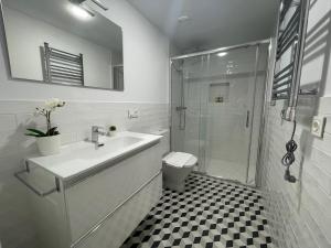 a white bathroom with a sink and a shower at housingcoruña SAN NICOLAS 27 in A Coruña
