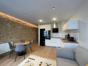 a kitchen and a living room with a couch and a table at housingcoruña SAN NICOLAS 27 in A Coruña +17 photos