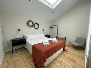 a bedroom with a bed with a red blanket and a chair at housingcoruña SAN NICOLAS 27 in A Coruña