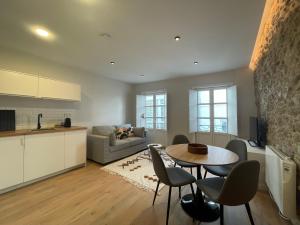 a kitchen and a living room with a table and chairs at housingcoruña SAN NICOLAS 27 in A Coruña