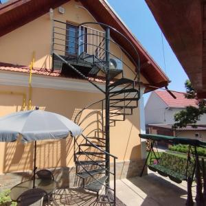 a spiral staircase outside of a house with an umbrella at Un sejur de neuitat. in Cristian