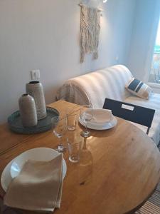 una mesa de madera con copas de vino encima en Très joli studio & balcon - Grasse 30 m² en Grasse