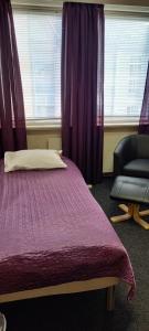sypialnia z łóżkiem, krzesłem i oknem w obiekcie Ekirom w mieście Egersund