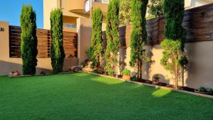 a garden with a green lawn in front of a building at Cypress Garden House in Ayía Marína