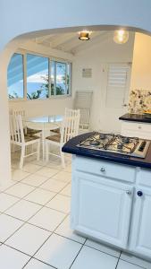 a kitchen with a stove top oven next to a table at Villa Ocean Blu in Cap Estate
