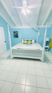 uma cama branca num quarto azul com tecto em Villa Ocean Blu em Cap Estate