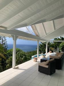 a covered porch with a view of the ocean at Villa Ocean Blu in Cap Estate