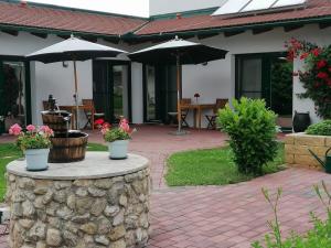 a patio with a table with umbrellas and flowers at Gästehaus Samira in Purbach am Neusiedlersee