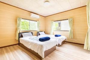 2 camas en una habitación con 2 ventanas en ウッドペッカーC棟 en Nasu