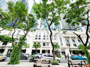a street with benches and trees in front of a building at Casa Antonio At Uptown Parksuites Two in Manila