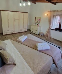 a large bed with two towels on it in a room at La Corte Liberty Rosa in Iglesias