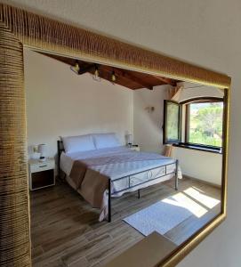 ein Schlafzimmer mit einem großen Bett und einem großen Spiegel in der Unterkunft La Corte Liberty Rosa in Iglesias