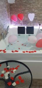 une table blanche avec des coeurs rouges et des fleurs sur elle dans l'établissement Dolce Notte, à Tarente